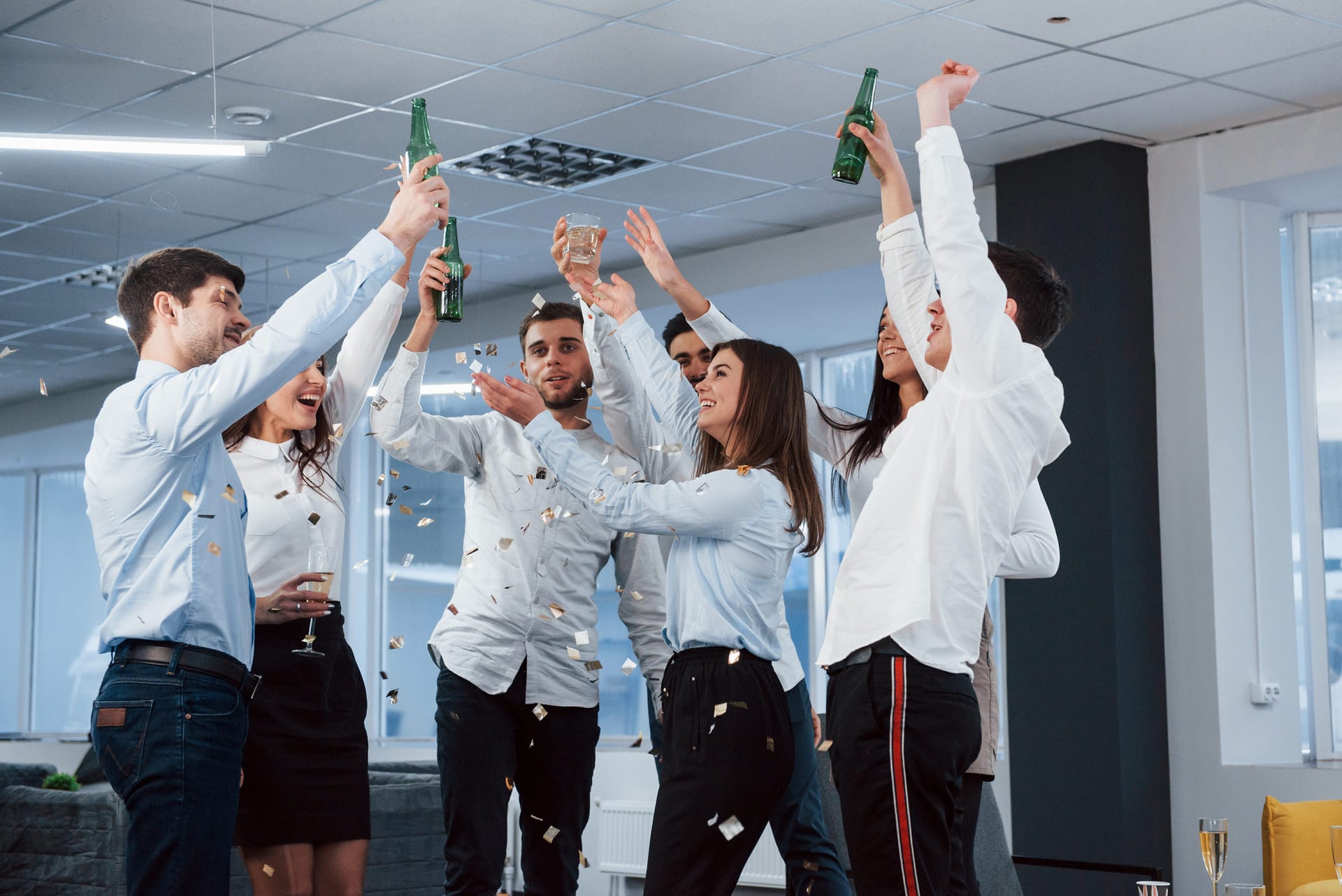 finally-we-got-it-photo-young-team-classical-clothes-celebrating-success-while-holding-drinks-modern-good-lighted-office (1)